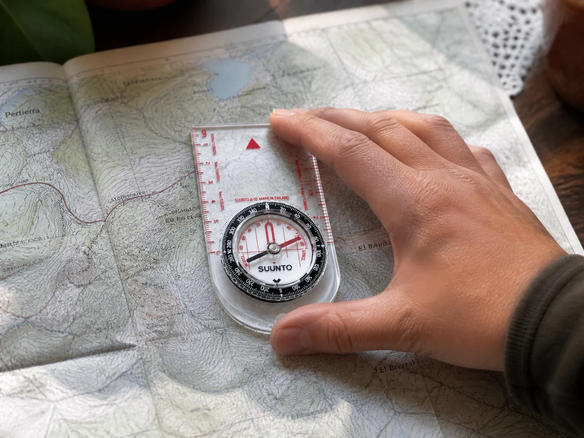 Brújula de placa sobre un mapa de papel en una mesa