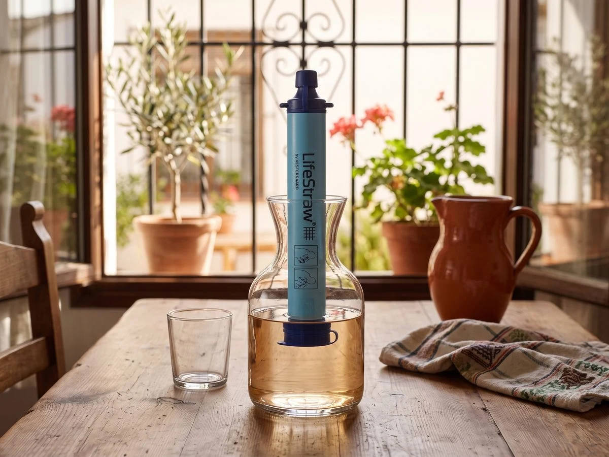 Filtro personal LifeStraw junto a un recipiente de agua