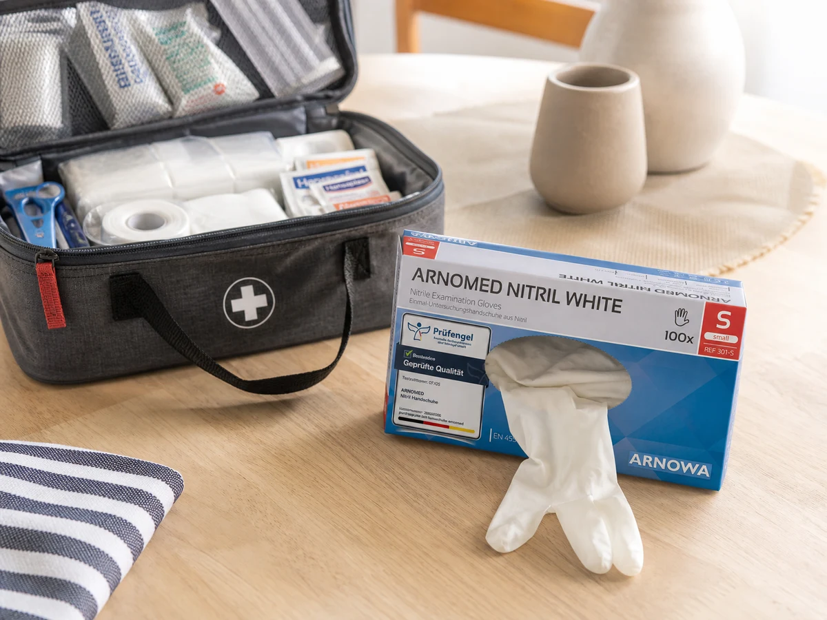 Caja de guantes de nitrilo abierta junto al botiquín