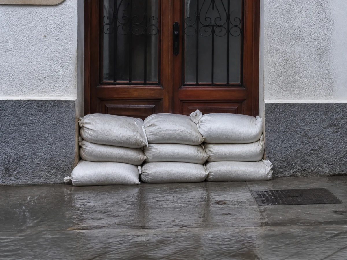 Sacos apilados delante de la puerta de casa para frenar el agua
